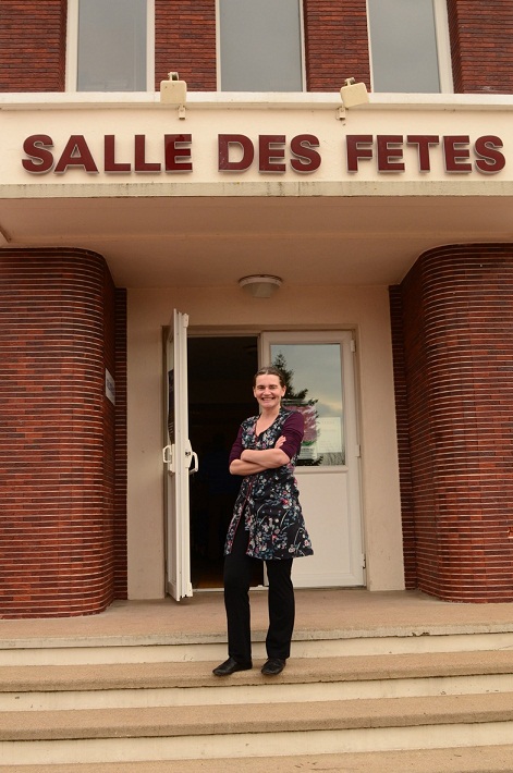 Véronique Blot, en costume de Bernadette la braconnière, est devant
            	l'entrée de la salle des fêtes d'Yvoy-le-Marron dans le Loir-et-Cher,